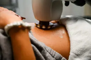 A person using an electric iron on the arm of another person.