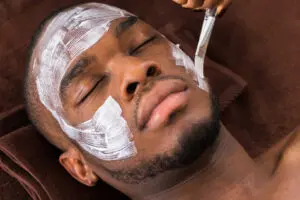 A man with white face mask on his head.