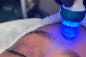 A person getting their face illuminated with blue light