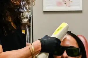 A woman getting her hair cut with an electric razor.