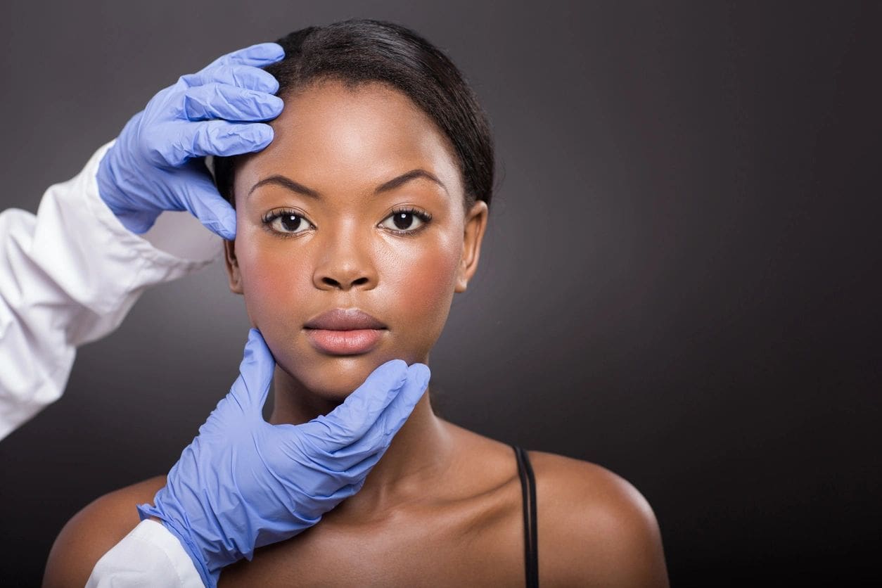 A woman getting her face waxed by an esthetician.